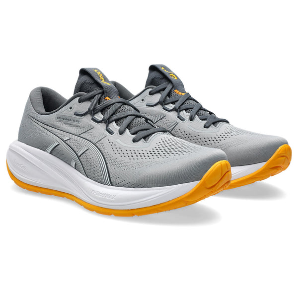 Gray running shoes with orange soles on a white background