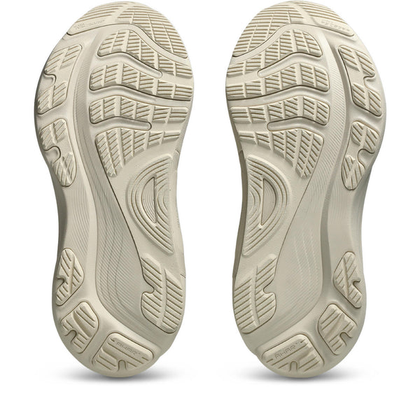 Close-up of beige shoe soles with tread pattern on a white background.
