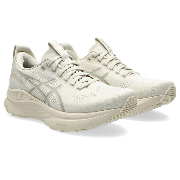 Pair of light-colored Women's ASICS running shoes on a white background.