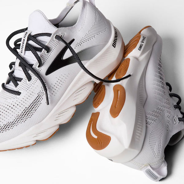 Men's white athletic shoes with brown outsole on a white background