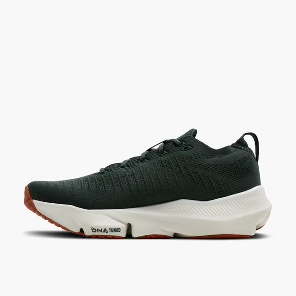 A dark green running shoe with a white midsole and orange outsole accents, shown on a light gray background.