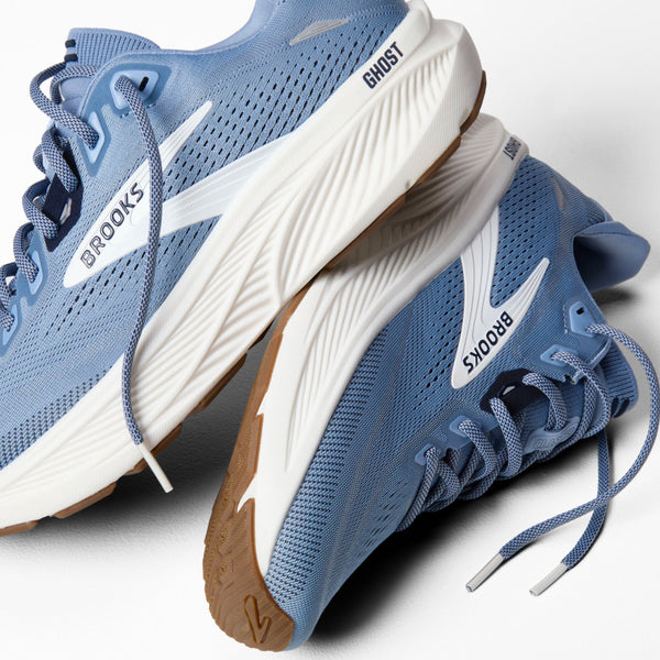 A pair of Brooks Ghost running shoes in light blue and white, with a gum-colored outsole, shown on a clean white background.