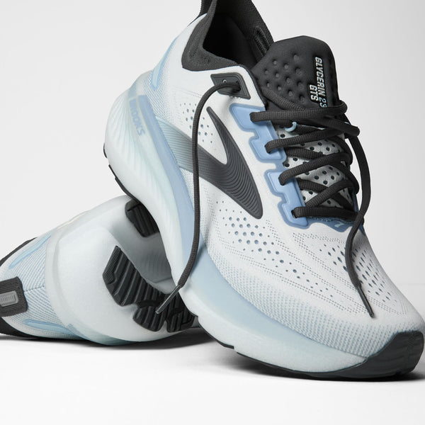 White and black athletic shoes with blue accents on a white background