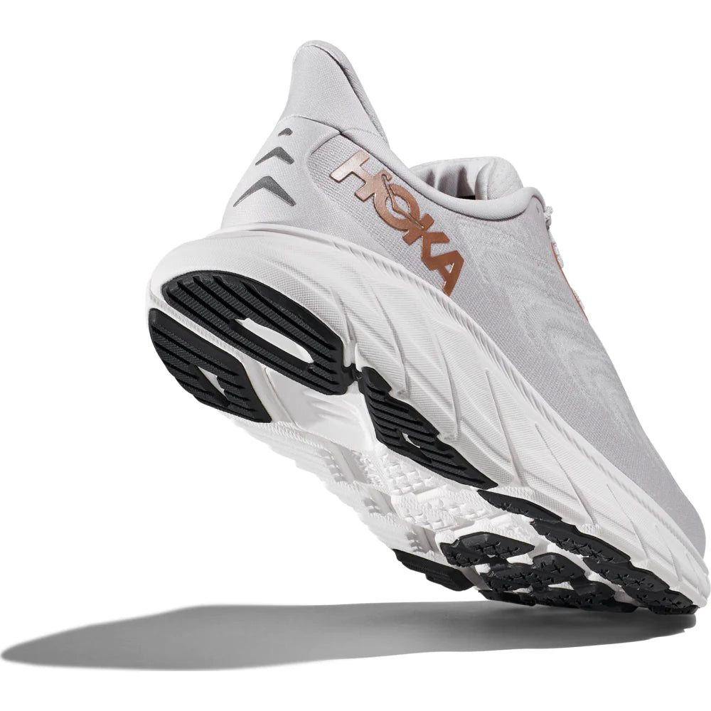 Back angle view of the Women's Arahi 6 by HOKA in the color Nimbus Cloud/Rose Gold