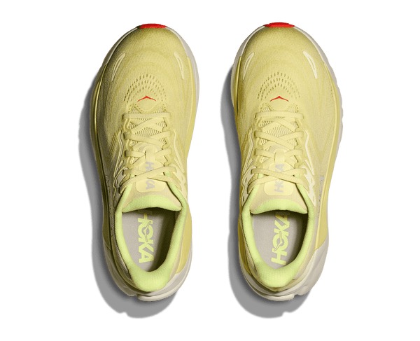 Pair of light yellow running shoes with white soles on a transparent background