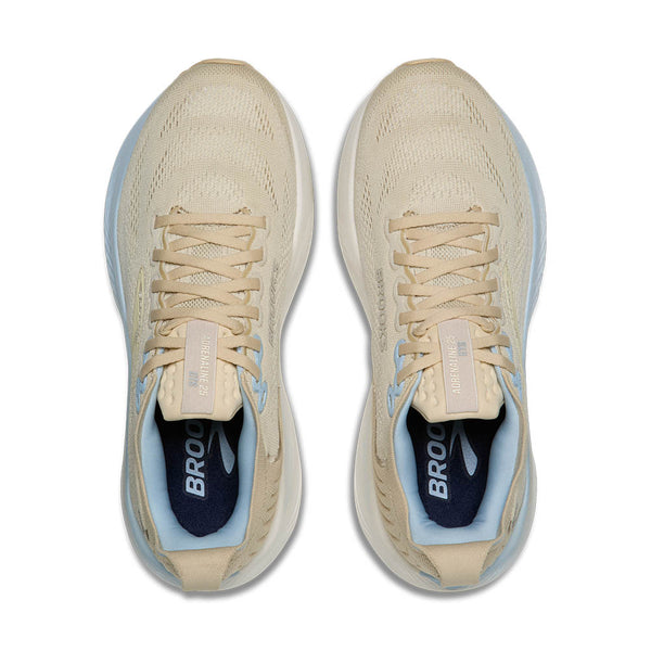 Pair of beige running shoes with blue accents on a white background