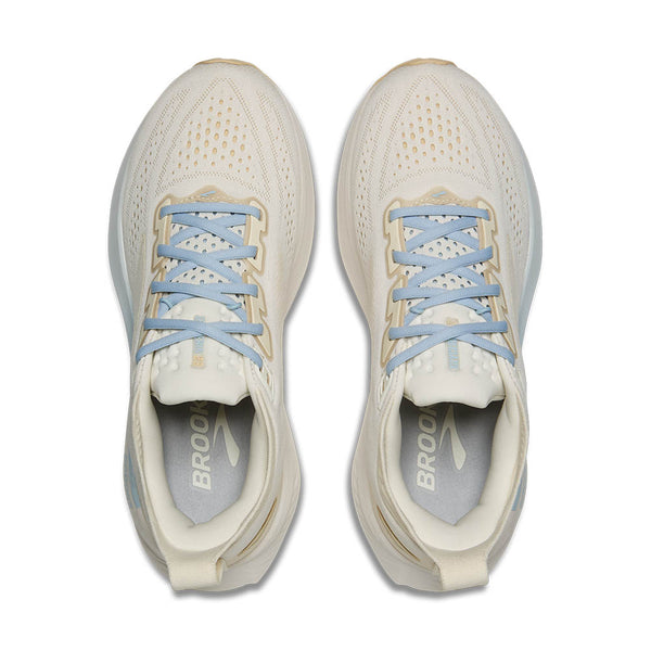 Pair of beige running shoes with light blue laces on a white background