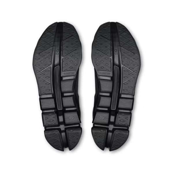 A pair of black athletic shoes shown from the sole view, displaying the textured rubber outsoles against a plain white background.