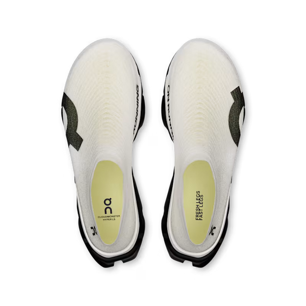Top-down view of a pair of cycling shoes on a white background, showing the white knit uppers, black soles, and light yellow-green footbeds with branding.
