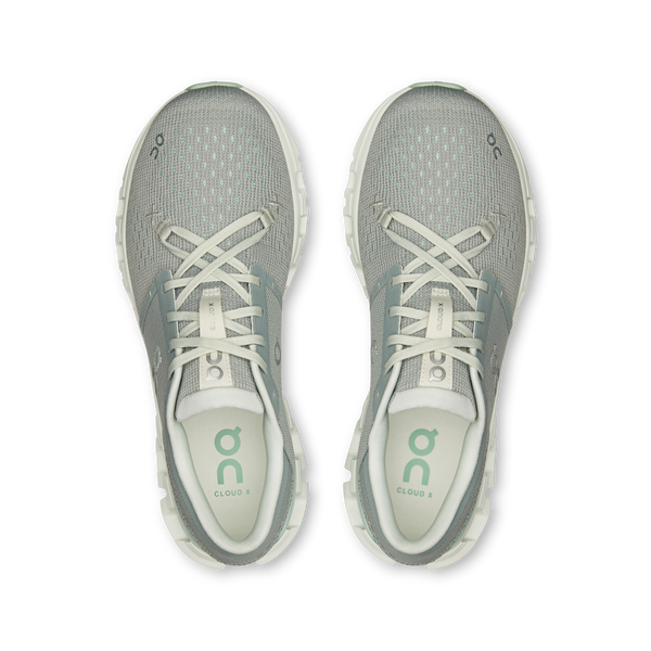 Pair of green athletic shoes with white laces on a white background