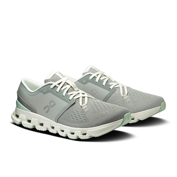 Green running shoes with white soles on a white background