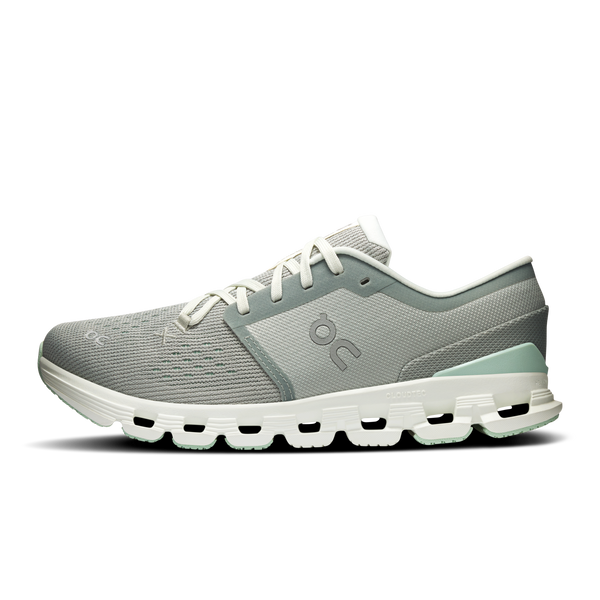Green running shoe with white sole on a white background