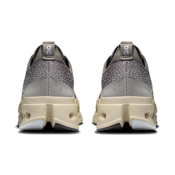 A pair of gray women's running shoes with beige sole on a white background