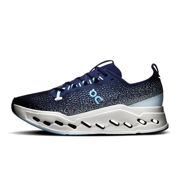 On running shoe in navy blue with a speckled pattern, a light blue On logo, and a white sculpted sole with black cutouts, shown against a plain white background.