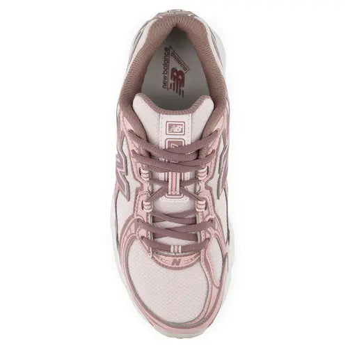 A New Balance athletic sneaker in dusty pink and white, shown against a plain white background.