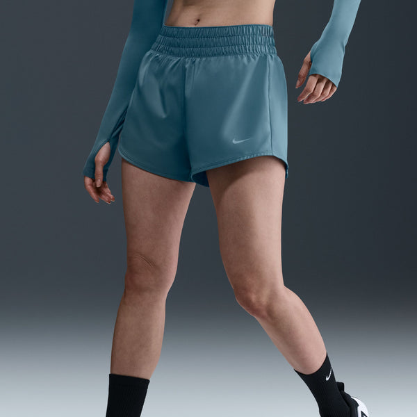 Person wearing blue athletic shorts on a dark background