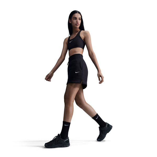 Woman wearing a black Nike athletic outfit on a white background