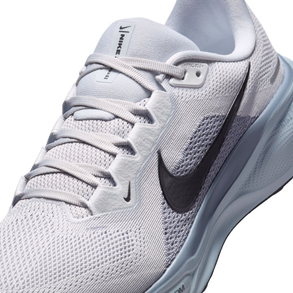 Super close up of a gray running shoe with black Nike logo on a white background.
