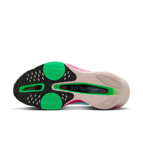 Sole of a sneaker with green, black, and pink colors on a white background.