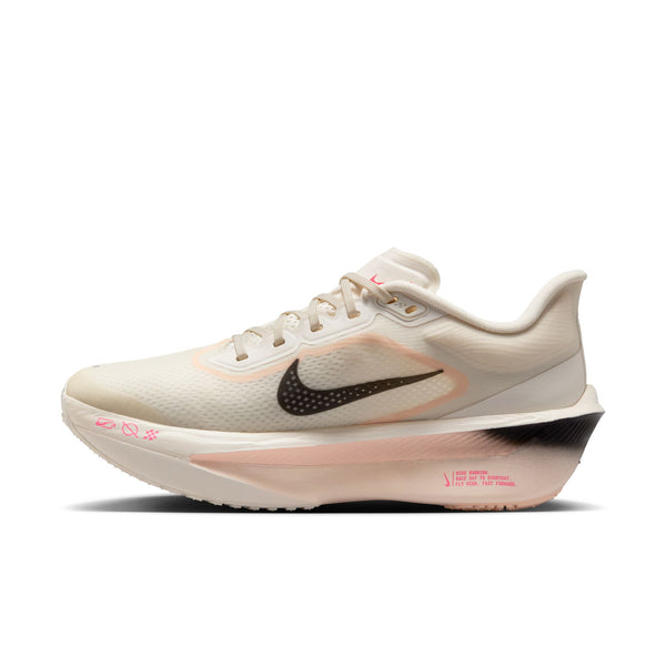 The medial side of this pale ivory colored Nike running shoe has a small black swoosh.