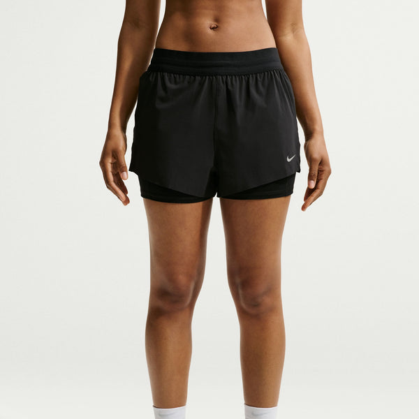 Person wearing black athletic shorts with a Nike logo on a white background
