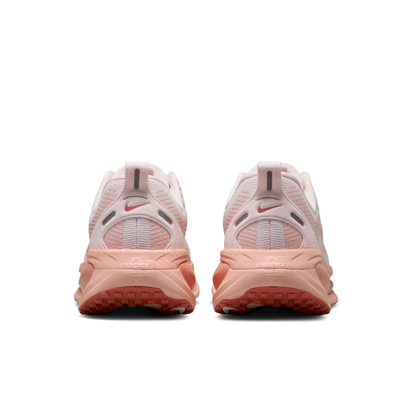 Pair of pink running shoes with Nike logo on a white background.