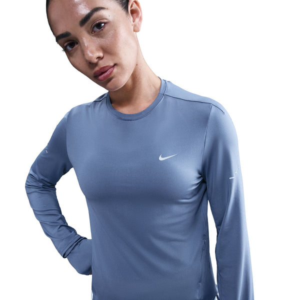 Woman wearing a blue Nike long-sleeve shirt on a white background