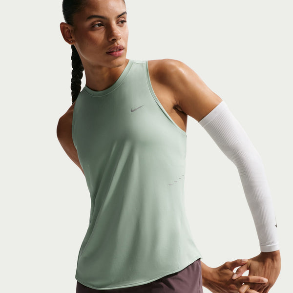 Woman wearing a green athletic tank top with a Nike logo on a white background