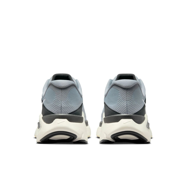 A pair of gray and white athletic shoes on a light gray background and a swoosh on the midsole.