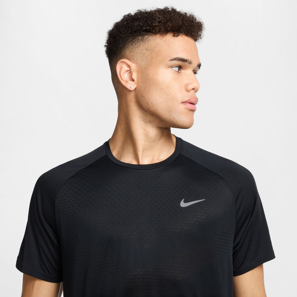 Man wearing a black Nike athletic shirt on a light gray background