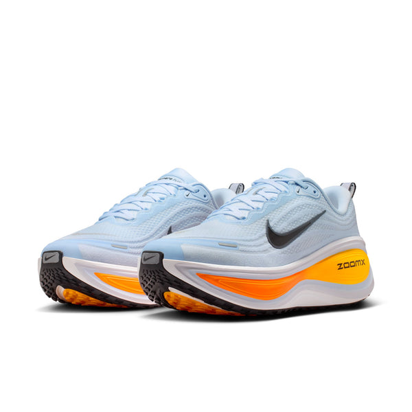 Pair of light blue running shoes with orange soles on a white background