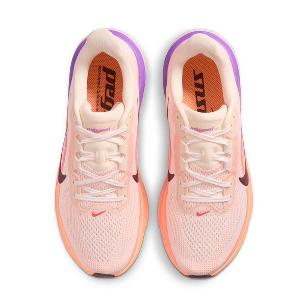 Pair of pink running shoes with white laces on a white background