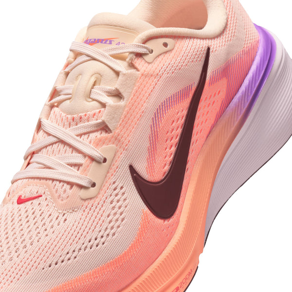 Close up on a women's nike shoe with light pink laces that match the upper material.