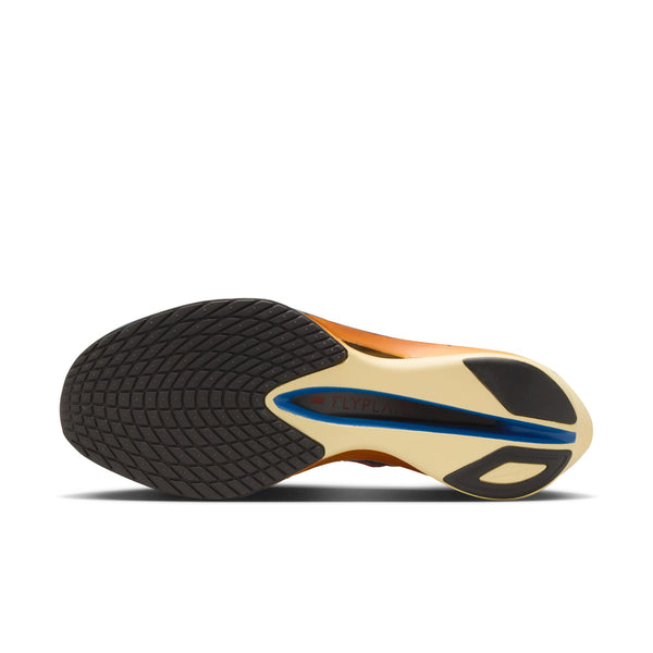 Close-up of a shoe sole with black tread pattern and gold and blue accents on a white background.