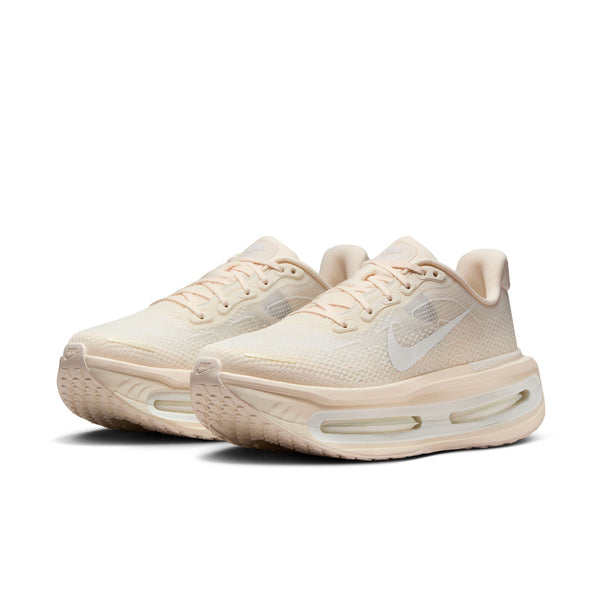Pair of beige women's tonal running shoes on a white background.