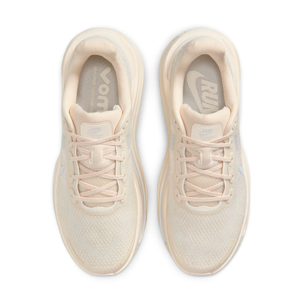 Pair of beige running shoes on a white background.