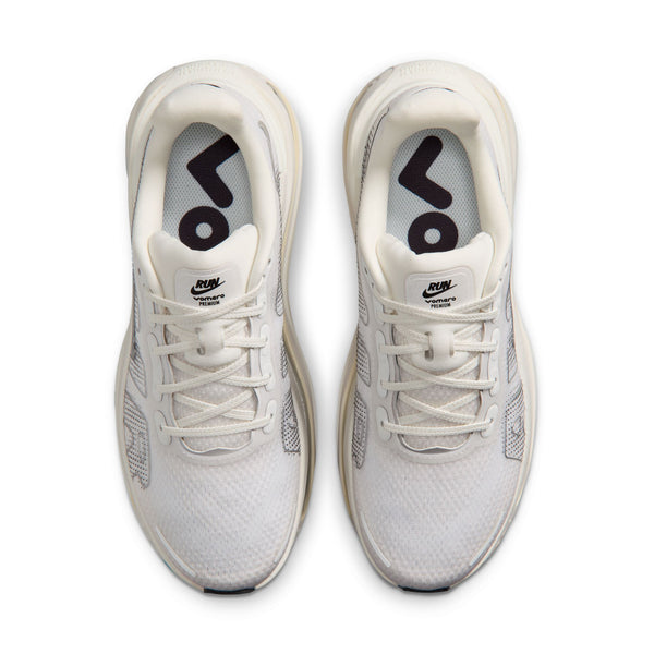 White athletic shoes with black logo on a white background