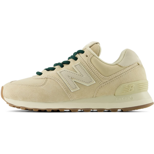 A New Balance sneaker in cream suede and leather with dark green laces, shown from on a white background.