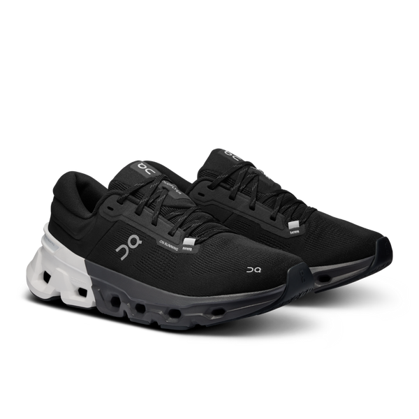 A pair of Women's on running shoes with a black upper and color blocked midsole.