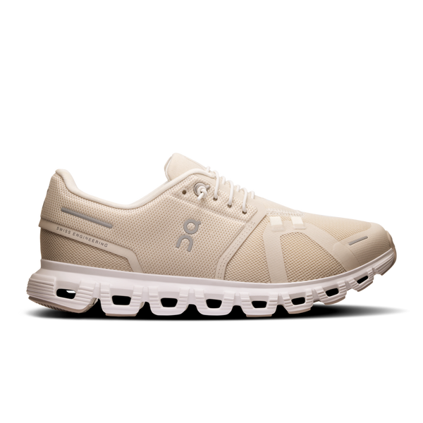 A pair of women's running shoes in beige color with a flexible white sole.