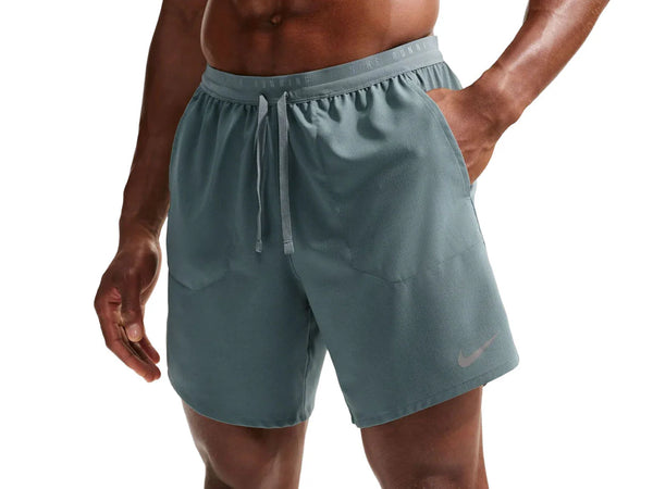 Person wearing teal athletic shorts with a Nike logo on a white background