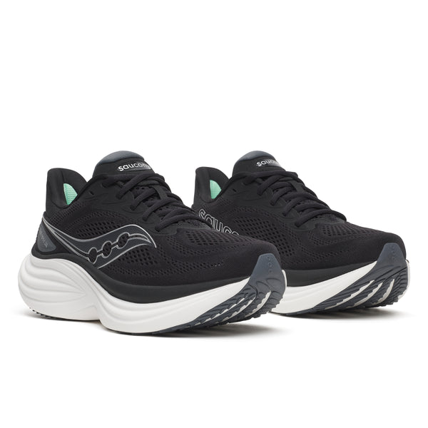 Black and white women's wide Saucony running shoes with white soles on a white background