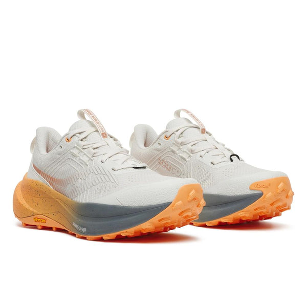 White running shoe with orange and gray sole on a white background