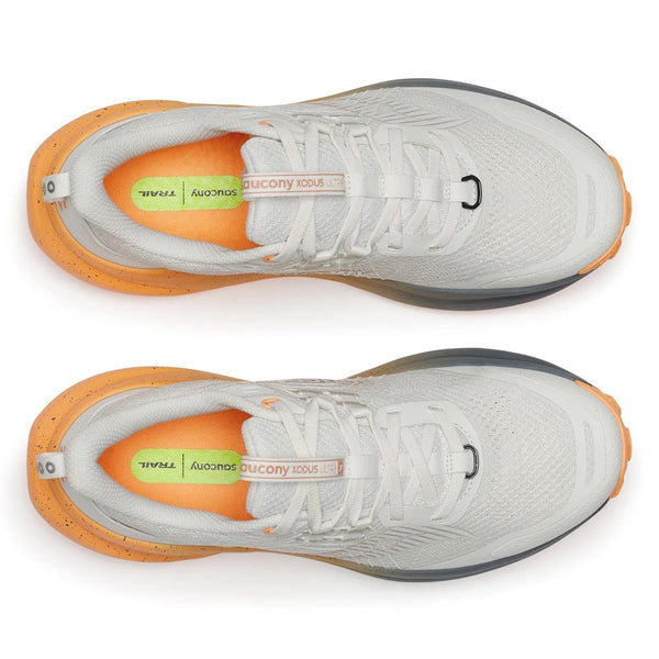 White running shoe with orange and gray sole on a white background
