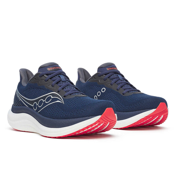Pair of navy running shoes with red soles on a white background.