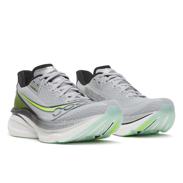 Gray running shoes with green accents on a white background
