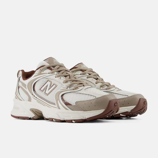 A New Balance athletic sneaker in beige, white, and brown, shown against a plain white background.
