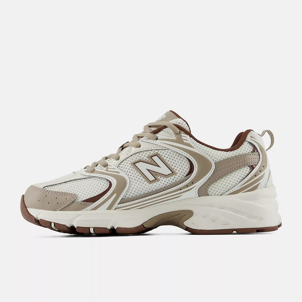 A New Balance athletic sneaker in beige, white, and brown, shown against a plain white background.