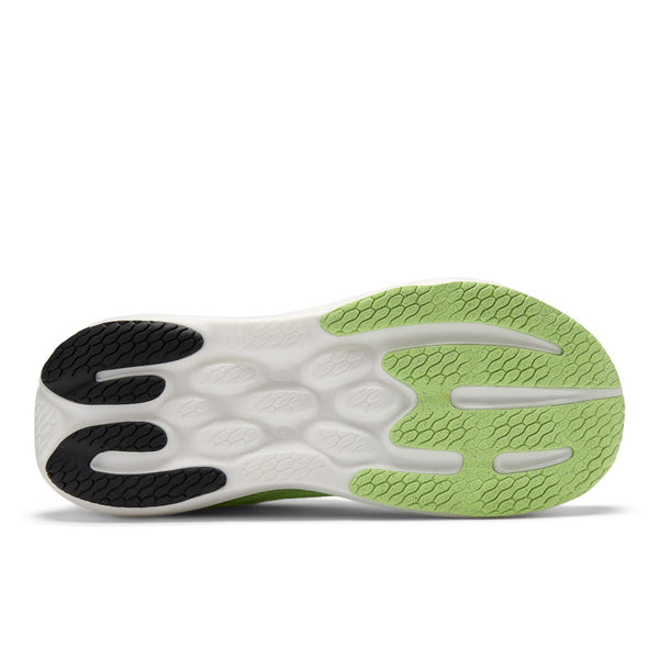 Close-up of a New Balance shoe sole with green and black pattern on a white background.