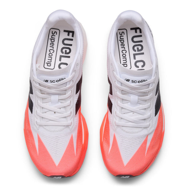 Top down look of a women's mostly white running shoes with orange accents on a white background.